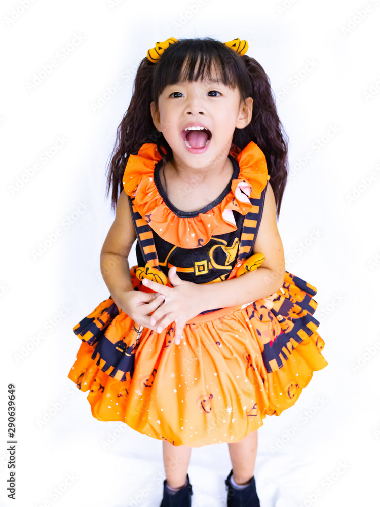 Asian children girl in pumpkin dress costume for Halloween decoration in white background Asian children girl in pumpkin dress costume for Halloween decoration in white background