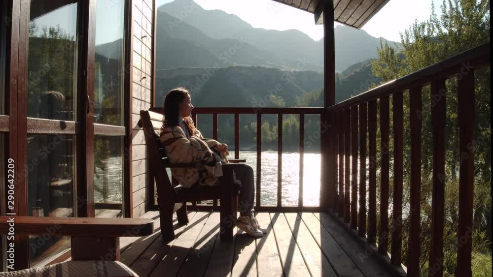 Young Woman Having A Rest And Enjoying Sunrise On Balcony Of A Country House Young Woman Having A Rest And Enjoying Sunrise On Balcony Of A Country House