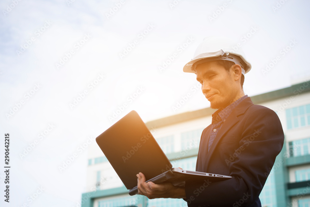 Engineer Notebook laptop work at building sky background Engineer Notebook laptop work at building sky background
