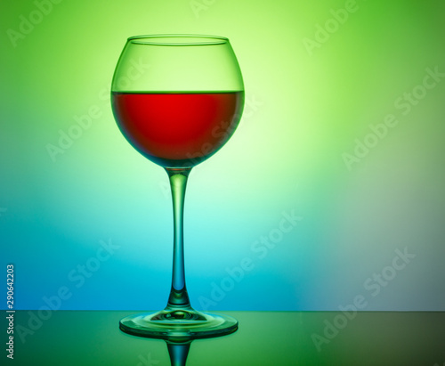 Wine glass with a drink on a colored light background