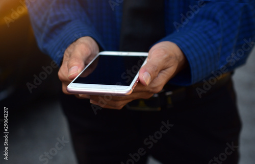 Fototapeta Naklejka Na Ścianę i Meble -  Close up businessman holding mobile smart phone