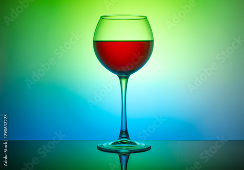 Wine glass with a drink on a colored light background
