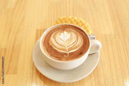 cup of coffee with whipped cream on wooden background