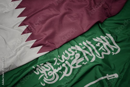 waving colorful flag of saudi arabia and national flag of qatar.
