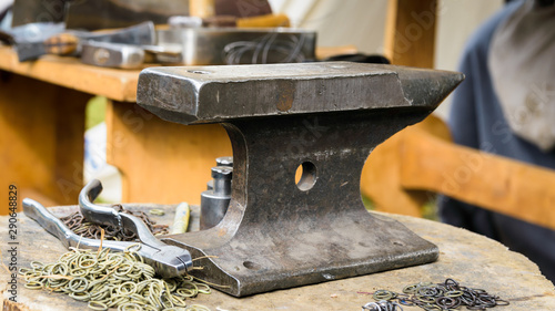 Slika na platnu anvil, tools, rings for chain mail on a log in a forge