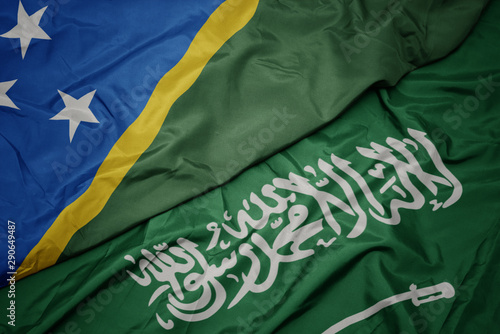 waving colorful flag of saudi arabia and national flag of Solomon Islands .