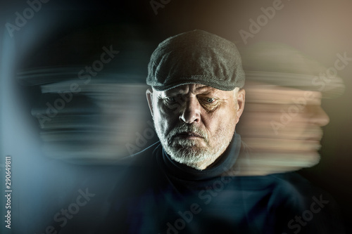 Foto Portrait of a senior man with flat cap in front of black background