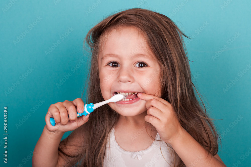 Cute little girl brushing her teeth - obrazy, fototapety, plakaty 