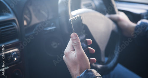 Man using a phone while driving a car.