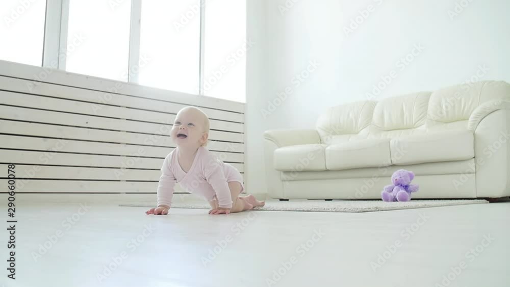 childhood, babyhood and family concept - happy little baby boy or girl sitting on floor at home childhood, babyhood and family concept - happy little baby boy or girl sitting on floor at home