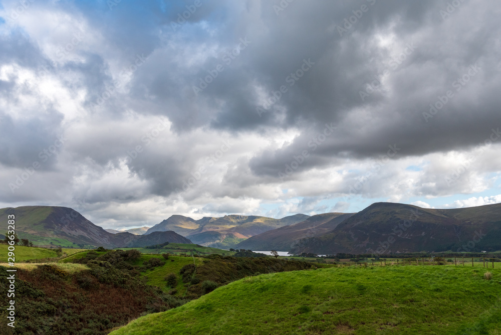 Dark and dramatic clouds loom over the English countryside in the Lake District, UK.