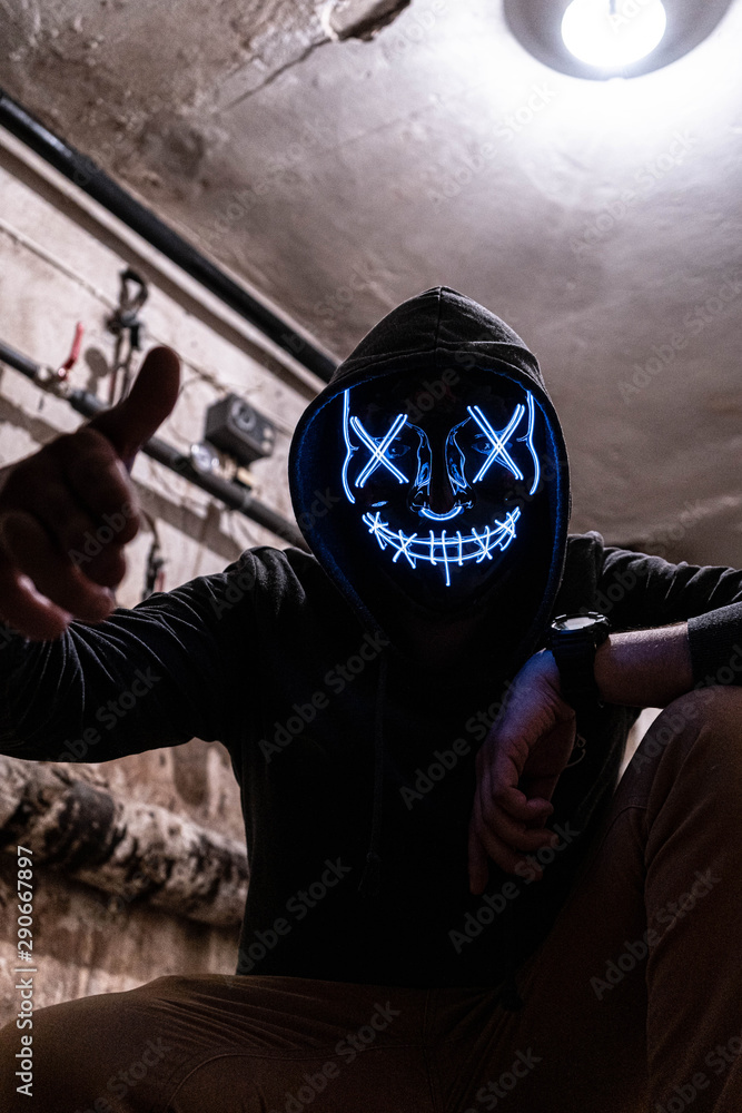 A man in a scary / creepy glowing LED mask in the basement. Stock Photo |  Adobe Stock