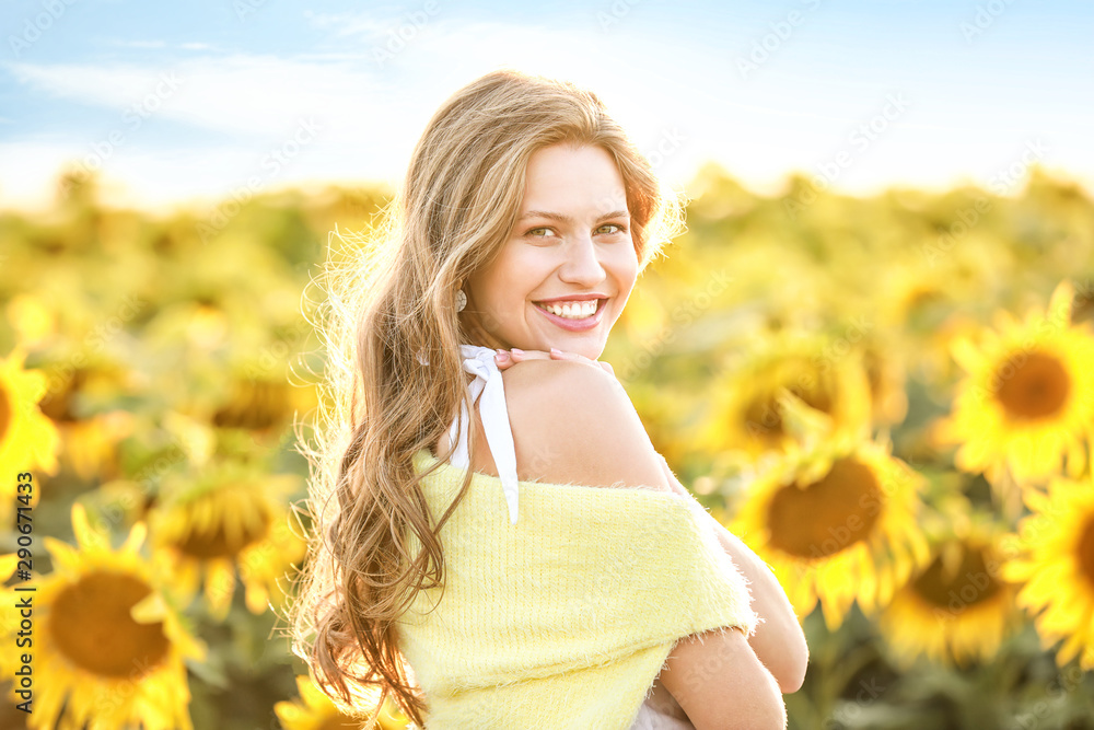 Beautiful young woman in sunflower field on summer day Beautiful young woman in sunflower field on summer day