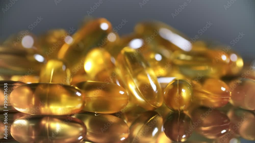 Cod liver oil omega 3 gel capsules rotation on black mirror surface Cod liver oil omega 3 gel capsules rotation on black mirror surface