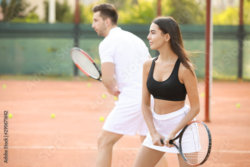 Young couple playing tennis on court