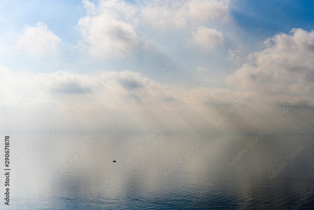 Obraz premium White cloudy sky over the pastel blue sea.