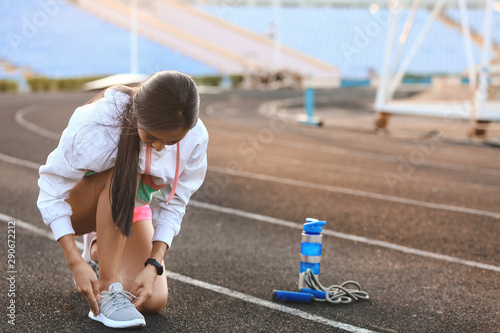 Sporty young woman tying sh...