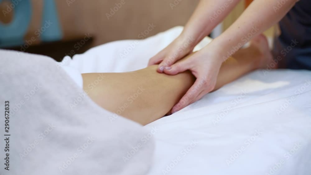 Spa body massage, the professional massage therapist makes a relaxing spa legs massage for young girl. Spa body massage, the professional massage therapist makes a relaxing spa legs massage for young girl.