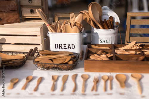 Different style of vintage wooden spoons on a table and basket with nice sunlight in the morning in Thailand. Horizontal shot.