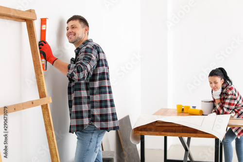 Happy couple doing repair i...