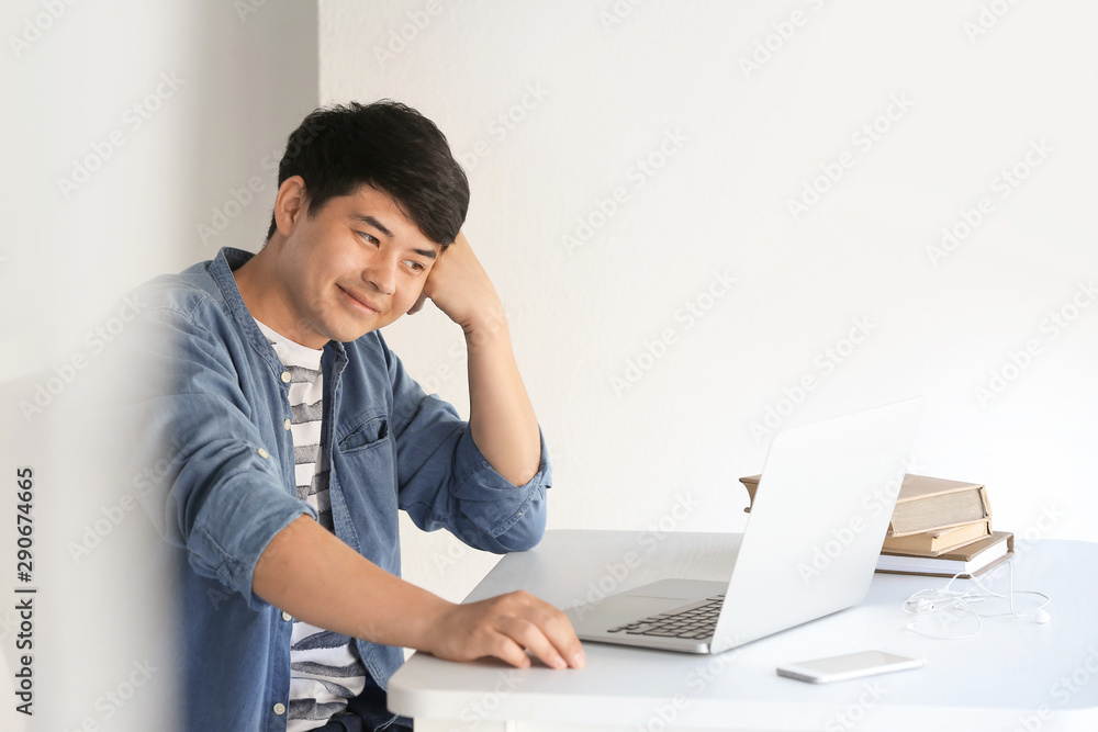Asian student with laptop preparing for exam at home Asian student with laptop preparing for exam at home