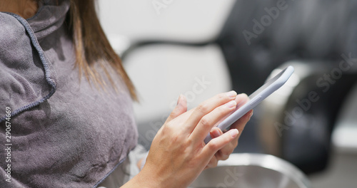Woman use of mobile phone in hair salon
