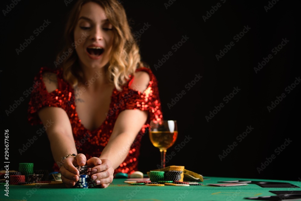 A girl raises bets with chips in a casino. Focus on chips, background for the gaming business. A girl raises bets with chips in a casino. Focus on chips, background for the gaming business.
