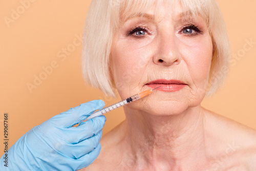 Close up photo amazing beautiful mature she her aged model lady surgeon medic nurse hold hands arms getting hyaluronic cosmetology injecting make lips increase nude isolated pastel beige background