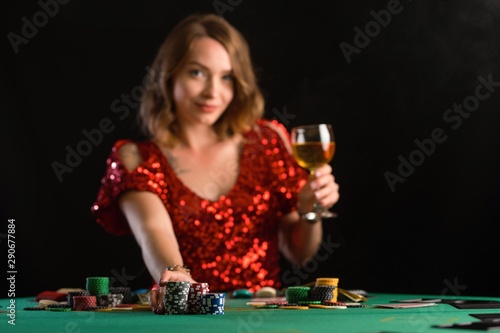 A girl raises bets with chips in a casino. Focus on chips, background for the gaming business.