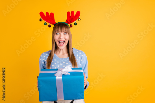 Giftbox from secret Santa concept. Photo of cheerful screaming celebrating optimistic with astonished facial expression hipster holding large wrapped package in hands isolated vivid color background