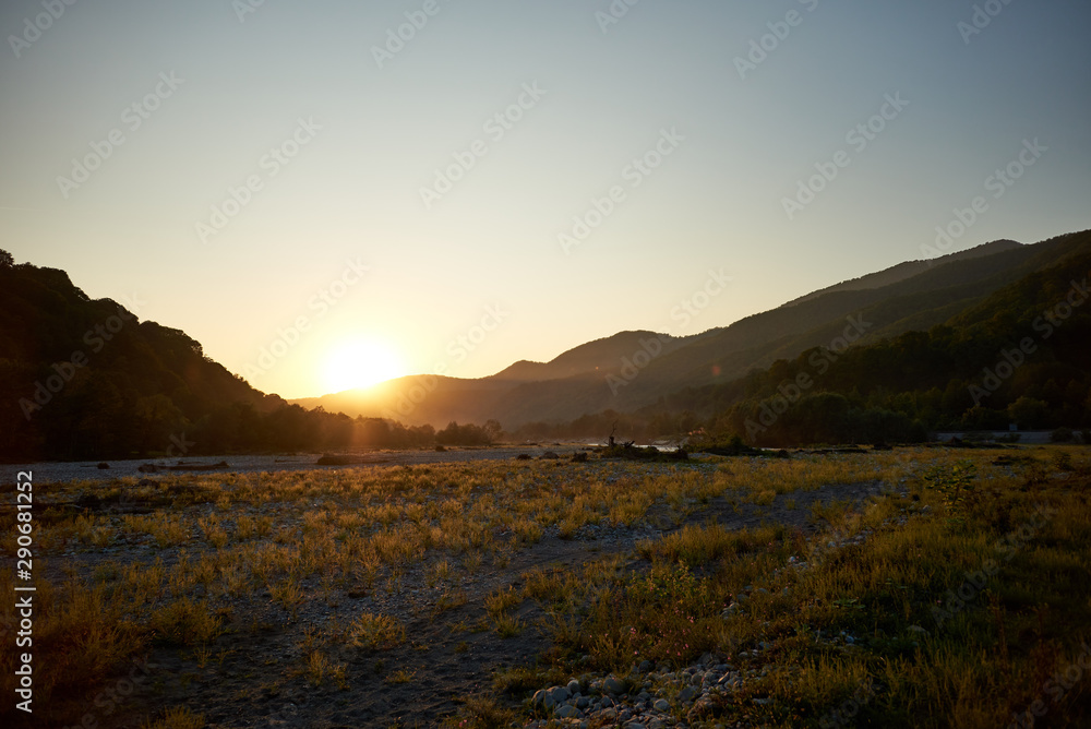 Sunset in a wide valley among the mountains. The colors of autumn. Natural landscape.