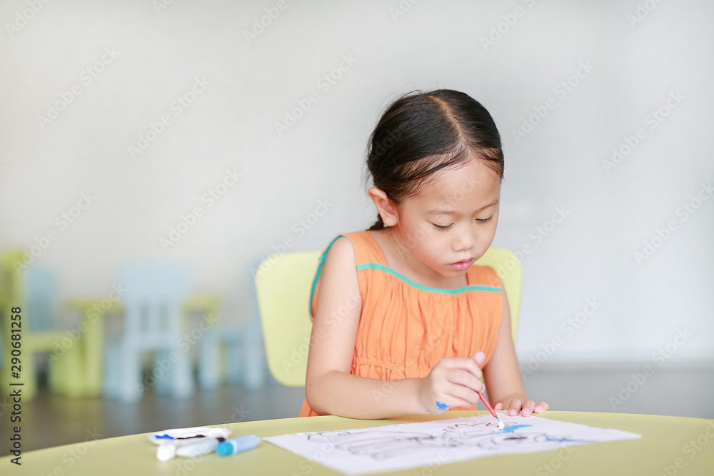 Adorable little Asian girl drawing and painting with water color on paper in children room Adorable little Asian girl drawing and painting with water color on paper in children room