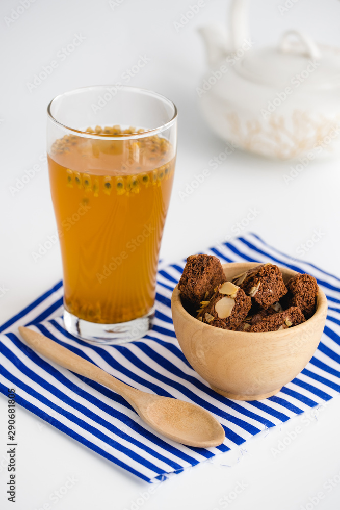 Glass of passion fruit tea, Refreshing summer drink and dessert on wood plate and minimal style background. Glass of passion fruit tea, Refreshing summer drink and dessert on wood plate and minimal style background.