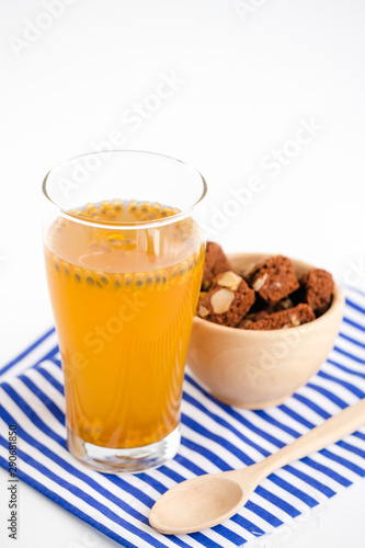 Glass of passion fruit tea, Refreshing summer drink and dessert on wood plate and minimal style background.