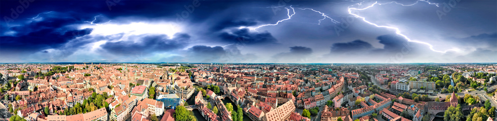 Aerial view of Nuremberg cityscape with river and medieval buildings with storm coming on background, Germany