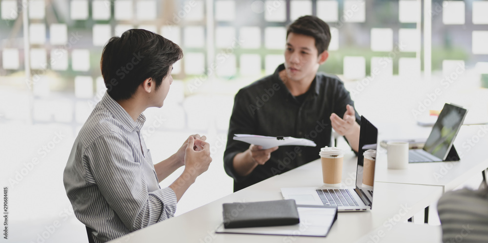 Two professional businessmen discussing their progress of their current project Two professional businessmen discussing their progress of their current project