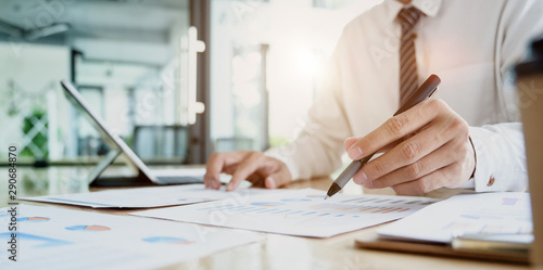 Male accountant compiling and analysing financial information to his client photo