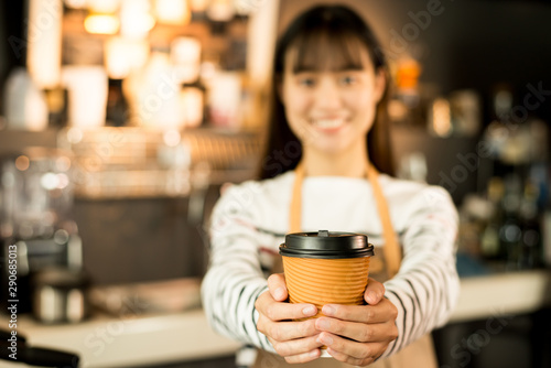 Young asian women barista hold coffee cup serving a client at the coffee shop start up small business owner food and drink concept..