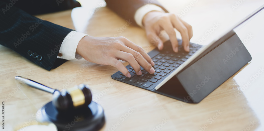 Lawyer working on a laptop and providing legal document for his client - obrazy, fototapety, plakaty 