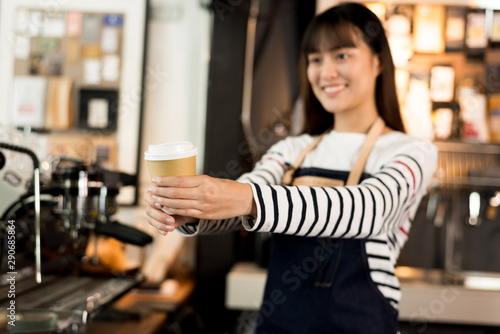 Young asian women barista hold coffee cup serving a client at the coffee shop,start up small business owner food and drink concept..