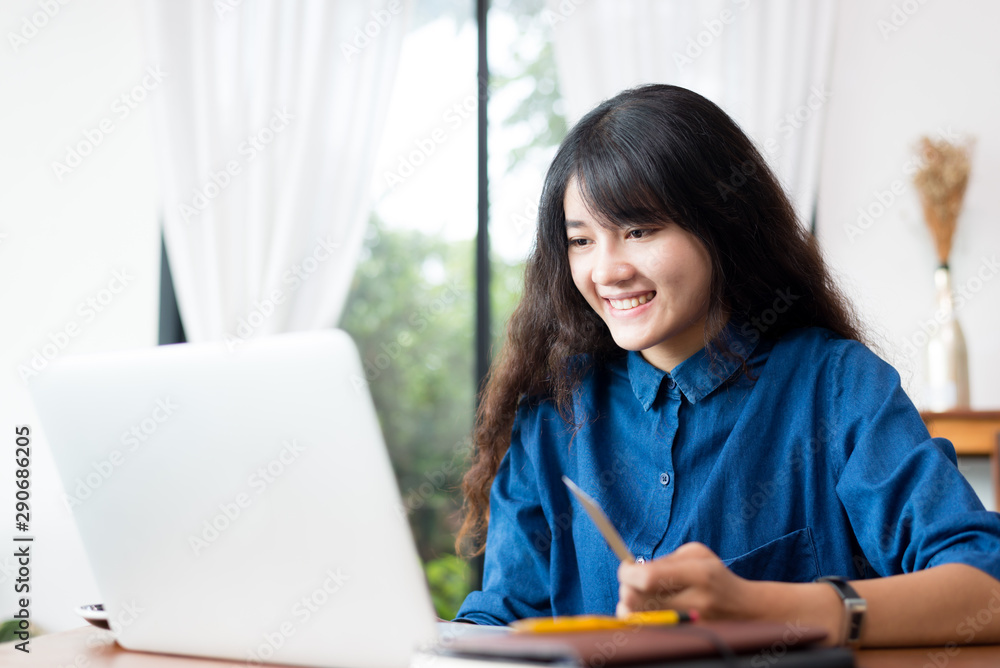 Young woman or student using laptop and shoping online sitting at coffee shop. Happy girl working online or studying and using notebook. Freelance business concept. Young woman or student using laptop and shoping online sitting at coffee shop. Happy girl working online or studying and using notebook. Freelance business concept.