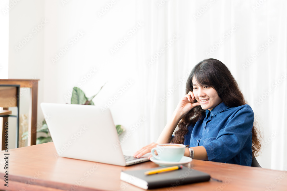 Young woman or student using laptop sitting at coffee shop. Happy girl working online or studying and using notebook. Freelance business concept. Young woman or student using laptop sitting at coffee shop. Happy girl working online or studying and using notebook. Freelance business concept.