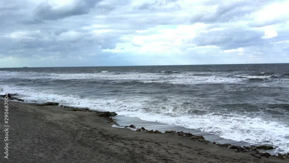 Dark beach of Florida with sand and waves on a overcast winter afternoon Dark beach of Florida with sand and waves on a overcast winter afternoon