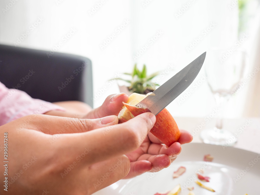 Slices of fresh red apple,Peeled apples,peel,knife,dish,white,Rad, background Slices of fresh red apple,Peeled apples,peel,knife,dish,white,Rad, background