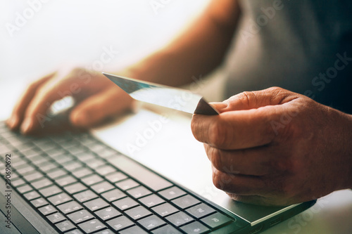 Old man shopping online with credit card. Older society adapting to news technologies.