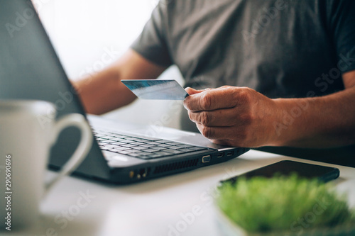 Old man shopping online with credit card. Older society adapting to news technologies.