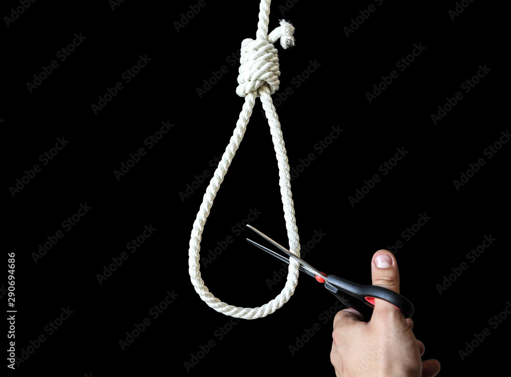 Noose isolated on black background. Man holding scissors in hands. Suicide concept. Hanging because of work stress. Depression or burnout. Terrible life situation. Life choice.