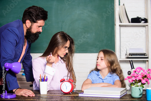 Little girl doing homework. Dad mom teaching child. Intelligent family. Greatest drawback overprotective parenting style underprepared children. Overprotective family. Overprotective parenting style photo