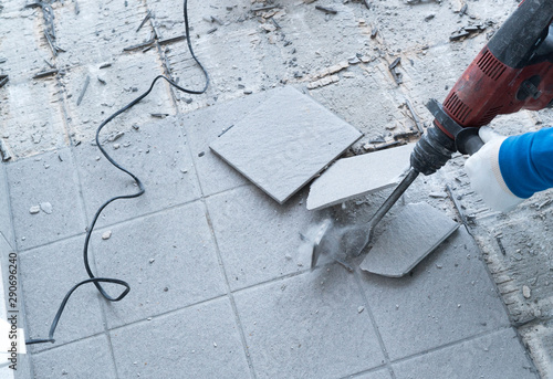 Fotografi construction worker using a handheld demolition hammer and wall breaker to chip