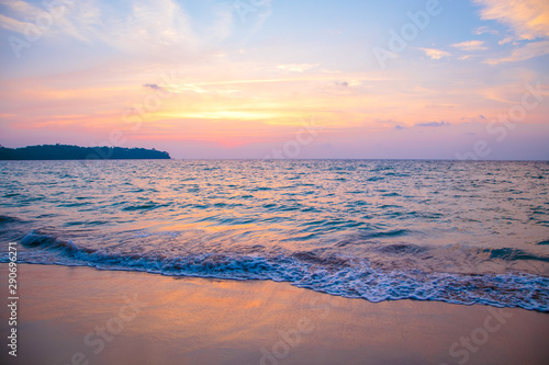 sunset on the sea. sandy beach  clear water  waves. surf line in the warm colors of the setting sun.